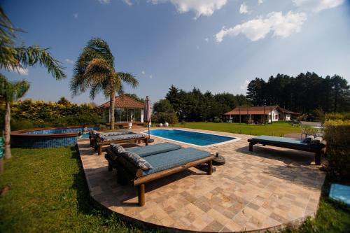a swimming pool with several benches next to a swimming pool at Rancho P&R in Balsa Nova