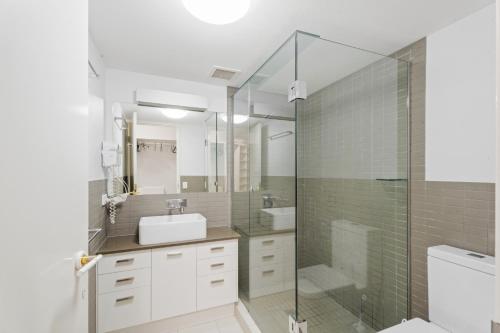 a bathroom with a sink and a shower at Charlton on The Esplanade in Hervey Bay