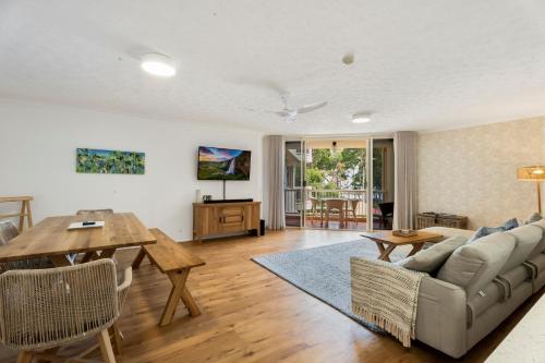 a living room with a couch and a table at Charlton on The Esplanade in Hervey Bay