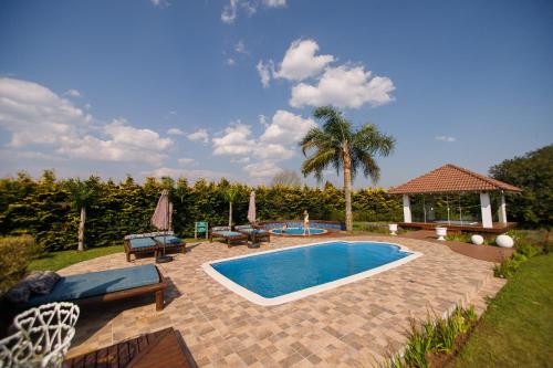 a swimming pool with chairs and a gazebo at Rancho P&R in Balsa Nova