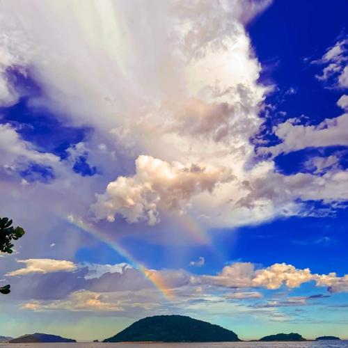 a rainbow in the sky with a cloudy sky at Pousada Refugio Prumirim in Ubatuba