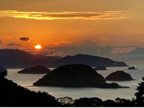 a sunset over a body of water with islands at Pousada Refugio Prumirim in Ubatuba