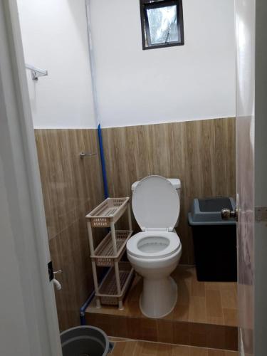 a bathroom with a toilet with a blue hose at NON AIRCON STUDIO TYPE UNIT Salvacion Palo Room 9 in Palo