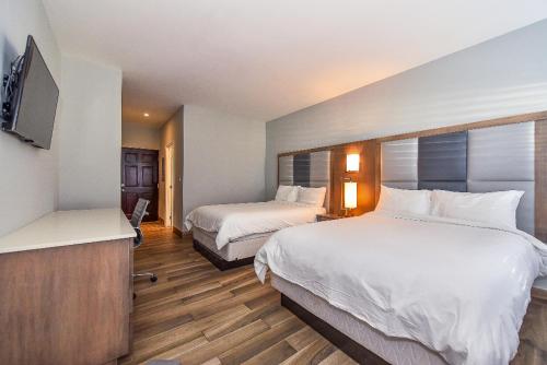 una camera d'albergo con due letti e una TV a schermo piatto di Hidden Haven I - Studio for 4 Near Beach a Turtle Cove