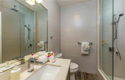 un bagno con lavandino, WC e specchio di Hidden Haven I - Studio for 4 Near Beach a Turtle Cove