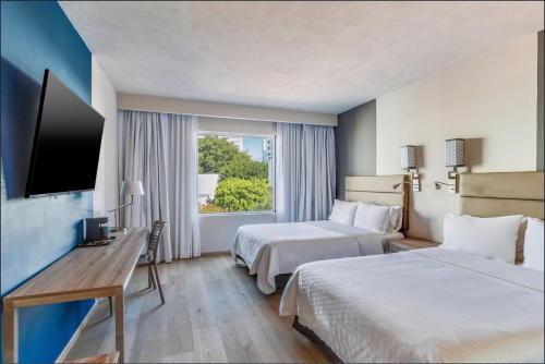 Ένα ή περισσότερα κρεβάτια σε δωμάτιο στο Fiesta Inn Monterrey Valle