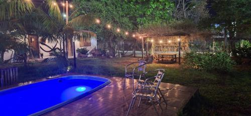 a backyard at night with a hot tub and chairs at Espaço Sairé - 8 minutos da Praia in Alter do Chao