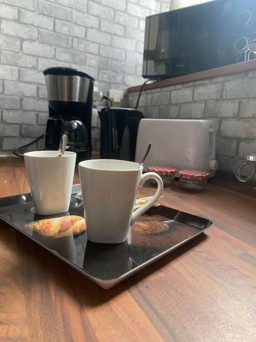 two coffee cups on a tray on a table at La Ptite maison du Canal in Drevant