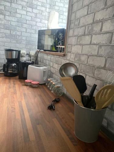 a kitchen with a hard wood floor and a wall at La Ptite maison du Canal in Drevant