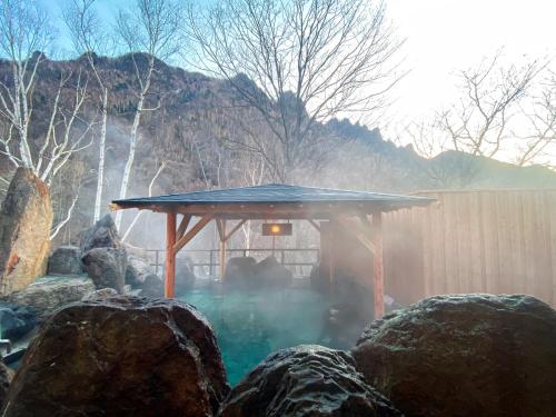 a gazebo in the middle of some rocks at 層雲閣 in Kamikawa