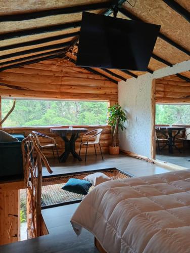 a bedroom with a bed and a table in a room at Cabaña en la calera el Pinar in La Calera