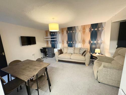 a living room with a couch and a table at Two bed spacious apartment, central location, free parking and Wifi in Birmingham