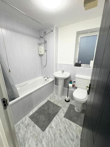 a bathroom with a toilet and a tub and a sink at Two bed spacious apartment, central location, free parking and Wifi in Birmingham