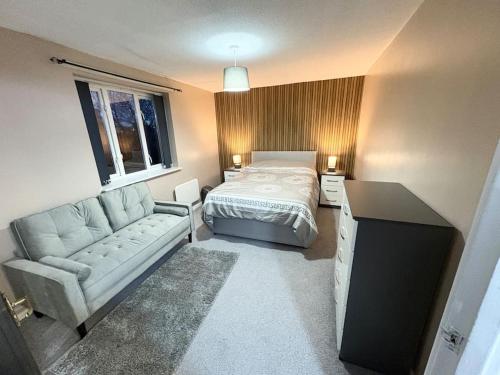 a small bedroom with a bed and a couch at Two bed spacious apartment, central location, free parking and Wifi in Birmingham