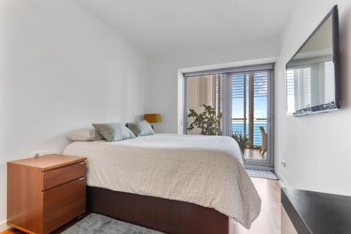 een witte slaapkamer met een bed en een raam bij Penthouse With The Best Views! in Barcelona