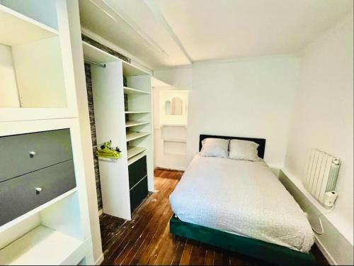 - une petite chambre avec un lit et un placard dans l'établissement Joli deux pièces porte de Paris, à Saint-Denis