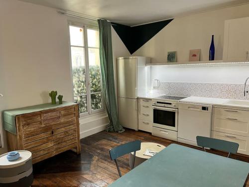 une cuisine avec une table et des chaises dans une pièce dans l'établissement Joli deux pièces porte de Paris, à Saint-Denis