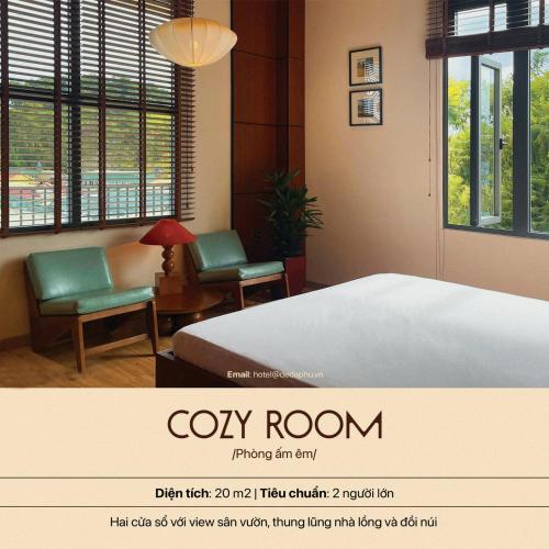 a hotel room with a bed and two chairs at Hôtel De Da Phu in Da Lat