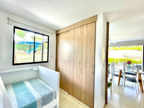 a small bedroom with a bed and a window at Vacaciones Eje Cafetero Parque del Cafe WIFI 114C in La Tebaida