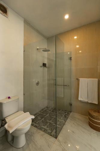a bathroom with a toilet and a glass shower at Sakya Villa Canggu By Bali Cabin in Canggu