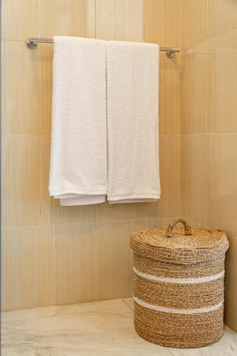 a bathroom with white towels and a basket at Sakya Villa Canggu By Bali Cabin in Canggu