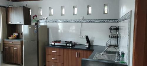 a kitchen with a stainless steel refrigerator and wooden cabinets at Mama Nings Beach Hotel in Sekongkang