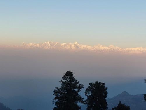 a view of a lake with mountains in the background at Himalayan view stay - Pahado wala ghar in Mussoorie