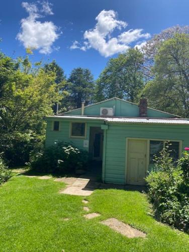 una casa verde con un garaje en el césped en Wandi General, en Wandiligong