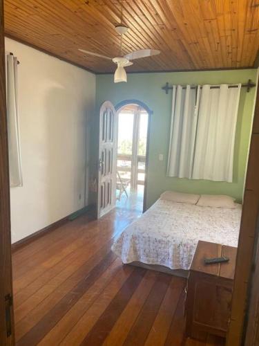 a bedroom with a bed and a wooden floor at Casa do coqueiro in Diamantina