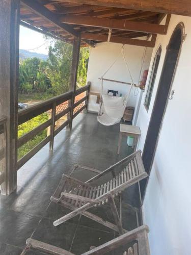 a porch with a hammock and a swing at Casa do coqueiro in Diamantina
