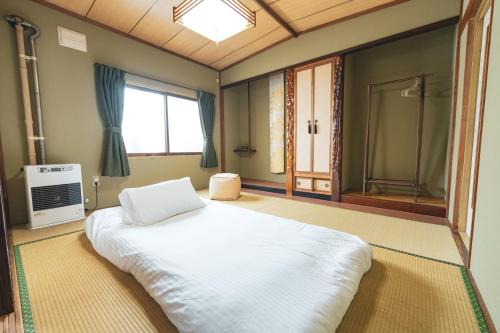 Shimo-furanoにあるRental Whole House Motomachiの大きなベッドと窓のある寝室
