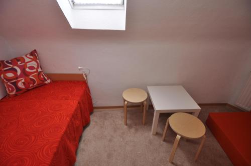 ein Schlafzimmer mit einem Bett, einem Tisch und zwei Hockern in der Unterkunft Ferienwohnung Martin 2 in Bad Harzburg