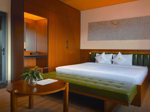 a bedroom with a large bed and a table at Hôtel De Da Phu in Da Lat