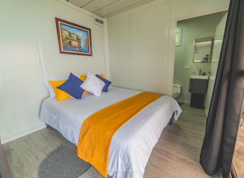 - une chambre avec un lit doté d'oreillers bleus et oranges dans l'établissement Dadirri Cozy House Santa Elena Monteverde, à Monteverde Costa Rica