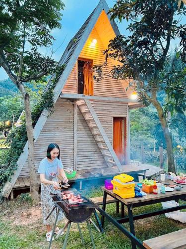 a woman preparing food in front of a house at May Homestay Soc Son - Venuestay in Hanoi