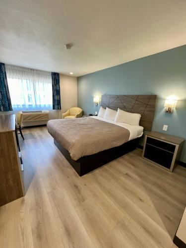 a bedroom with a large bed and a desk at Quality Inn Tracy I-205 in Tracy