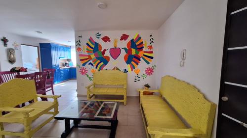 a room with yellow chairs and a painting on the wall at Vistas Pátzcuaro 115 in Pátzcuaro