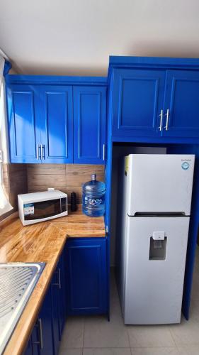 a kitchen with blue cabinets and a white refrigerator at Vistas Pátzcuaro 115 in Pátzcuaro