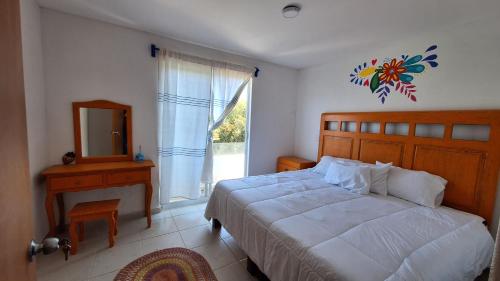 a bedroom with a bed and a mirror and a window at Departamento Vistas Pátzcuaro 115 in Pátzcuaro