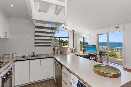 a kitchen with white cabinets and a view of the ocean at 3 Whitecrest Great Ocean Road Resort - Ocean Views in Wongarra