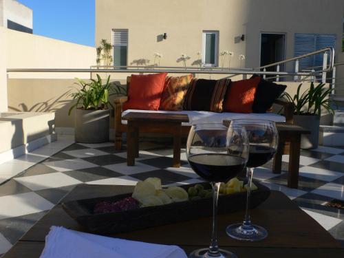 a couch and a glass of wine on a patio at Magnolia Hotel Boutique in Buenos Aires