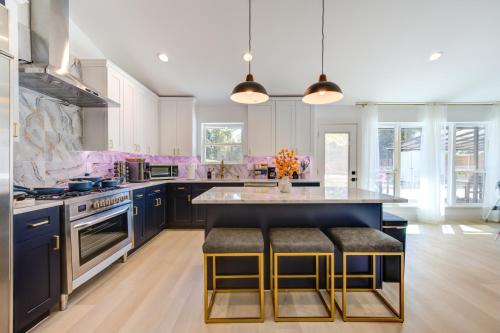 a kitchen with blue cabinets and a island with bar stools at Pickleball Paradise Retreat - 4 Bedrooms, 2,5 Baths - Houston Downtown, Houston Heights - Pickleball and Basketball Court, Pool, miniGolf, Karaoke, Fire Pit, BBQ, Billiards, Ping Pong, Hockey, King Bed in Houston