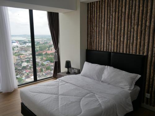 a bedroom with a white bed with a large window at Meisterstadt Pollux Habibie in Batam Center