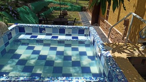 a swimming pool with a blue and white tile floor at Cabaña MACAREGUA - Curití Santander in Curití