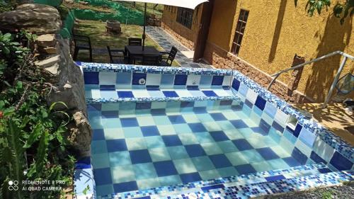 a swimming pool with blue and white tiles on it at Cabaña MACAREGUA - Curití Santander in Curití