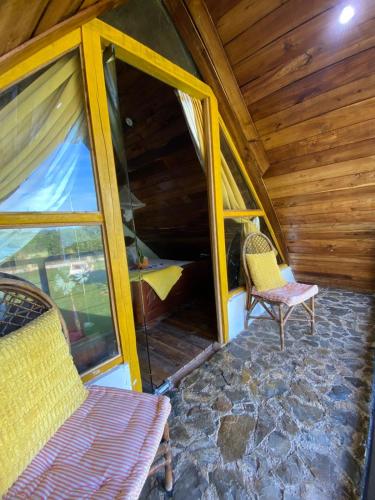 a room with two chairs and a window in a cabin at Dreamvilles Ecovillage Las Galeras in Las Galeras