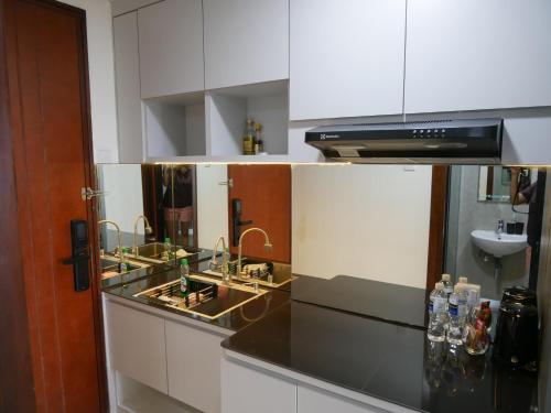a kitchen with a counter with two sinks and a sink at Meisterstadt Pollux Habibie in Batam Center