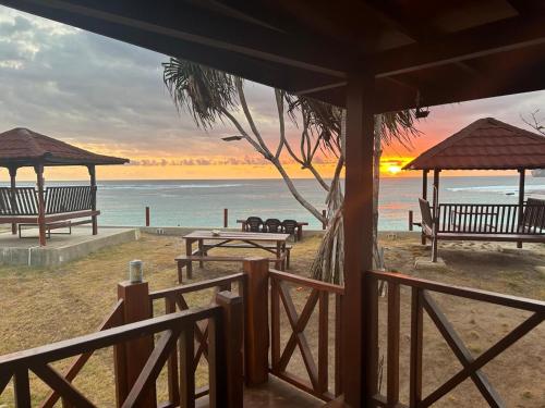 a view of a beach with benches and the ocean at Mama Nings Beach Hotel in Sekongkang
