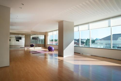 an empty room with large windows and wooden floors and a large room with yoga mats at Novotel Makassar Grand Shayla in Makassar