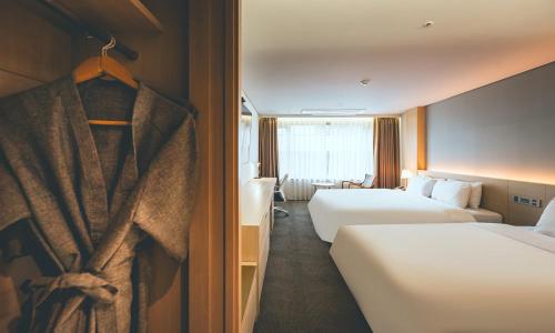 a hotel room with two beds and a window at Wonju City Hotel HYEOKSIN in Wonju